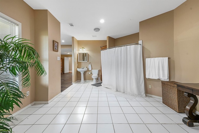 bathroom with a bidet, tile patterned flooring, and toilet