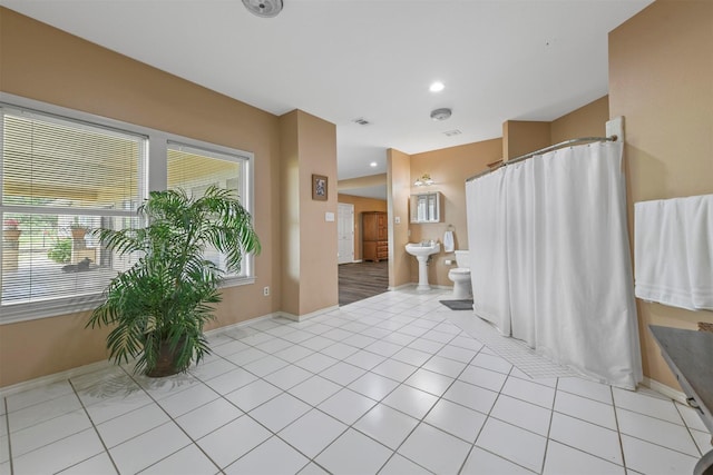 bathroom featuring toilet, tile patterned flooring, and a bidet