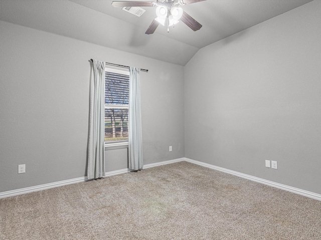 carpeted spare room featuring ceiling fan and vaulted ceiling