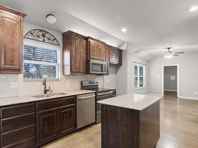 kitchen with appliances with stainless steel finishes, ceiling fan, dark brown cabinetry, sink, and lofted ceiling