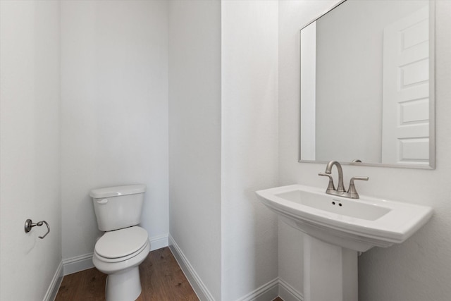 bathroom with sink, toilet, and hardwood / wood-style flooring