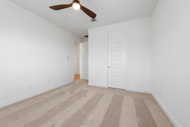 unfurnished bedroom featuring light colored carpet, ceiling fan, and a closet