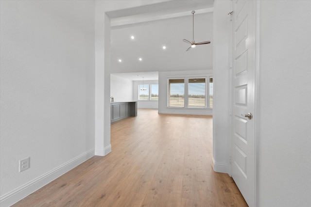 hallway featuring high vaulted ceiling, light hardwood / wood-style floors, and beam ceiling