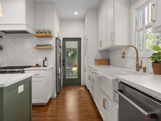 kitchen featuring stainless steel appliances, light stone countertops, custom range hood, white cabinetry, and tasteful backsplash