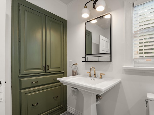 bathroom with sink, crown molding, and toilet