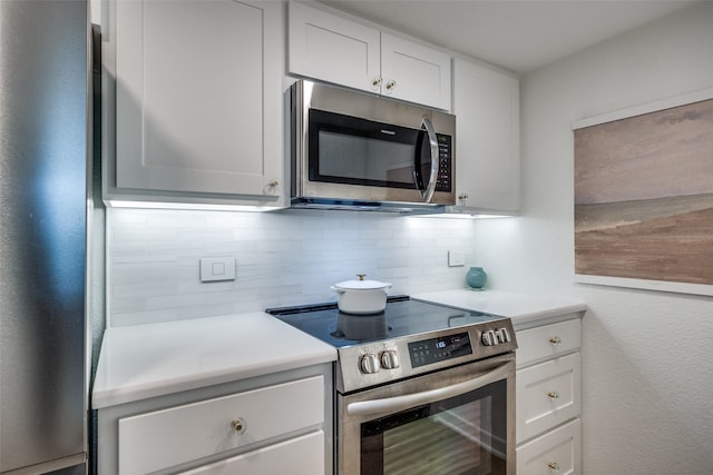 kitchen featuring decorative backsplash, stainless steel appliances, and white cabinetry