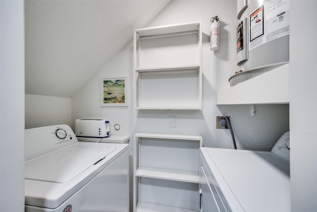 washroom with a textured ceiling and washer and clothes dryer