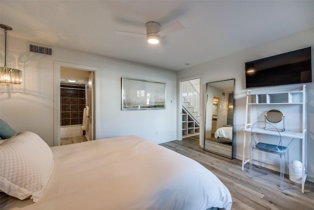 bedroom featuring ceiling fan, connected bathroom, and hardwood / wood-style flooring