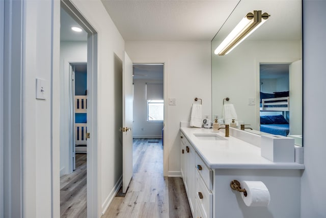 bathroom featuring hardwood / wood-style floors, vanity, and a textured ceiling