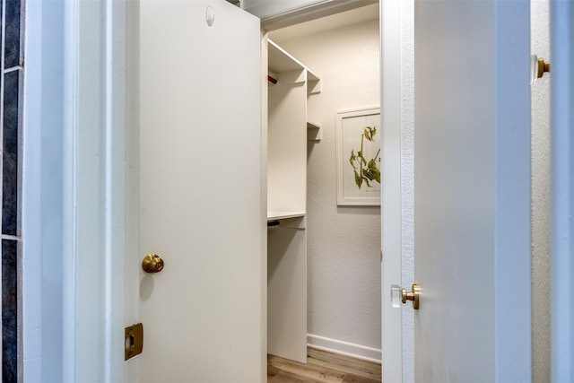 walk in closet featuring light hardwood / wood-style flooring