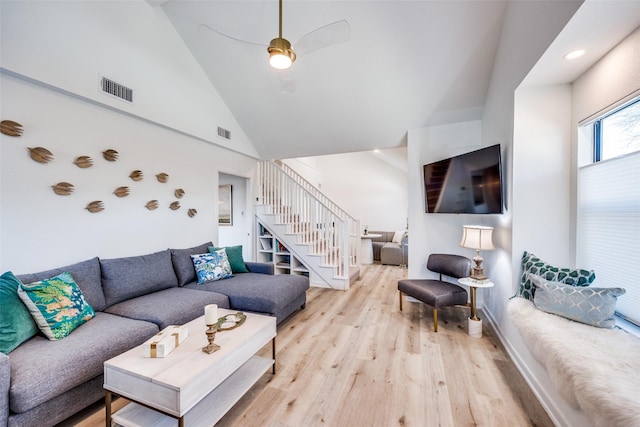 living room with high vaulted ceiling, light hardwood / wood-style flooring, and ceiling fan