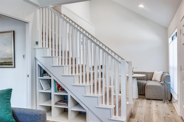 stairs with wood-type flooring and vaulted ceiling