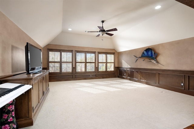 unfurnished living room with vaulted ceiling, light carpet, and ceiling fan