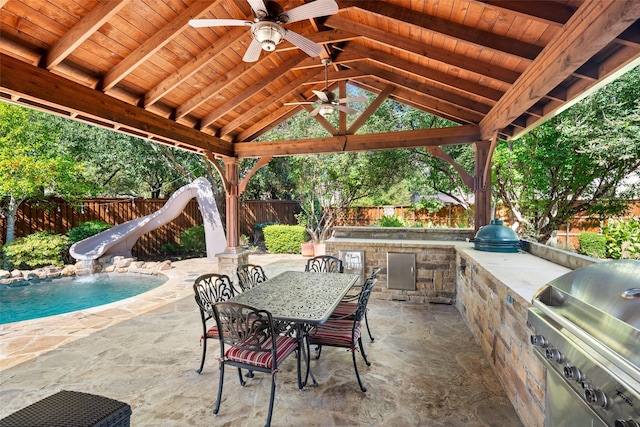 view of patio featuring a grill, a fenced in pool, pool water feature, area for grilling, and a gazebo