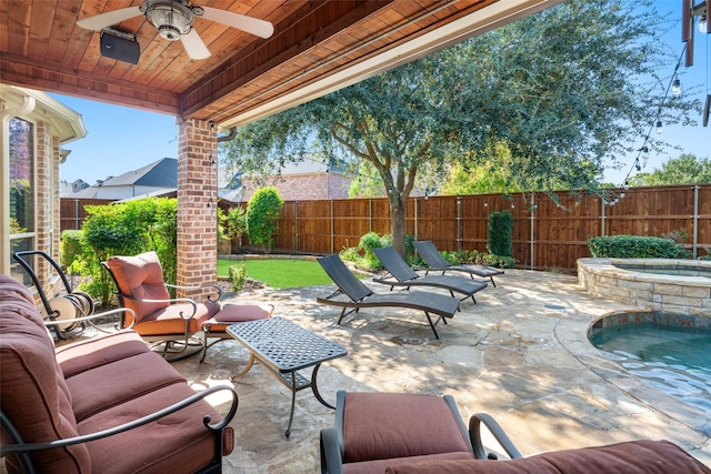 view of patio featuring ceiling fan and an in ground hot tub