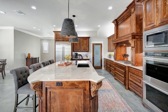 kitchen with a kitchen breakfast bar, a large island with sink, built in appliances, sink, and tasteful backsplash