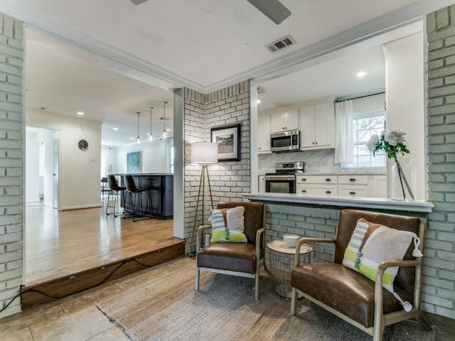 living area featuring brick wall and light tile patterned floors