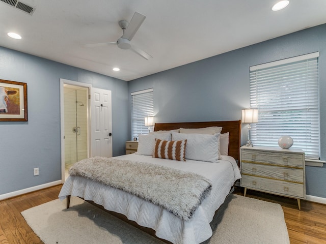 bedroom with hardwood / wood-style flooring, ceiling fan, and multiple windows