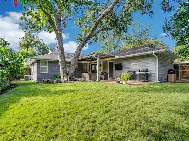 rear view of house with a lawn, central AC, and a patio area