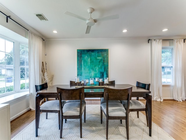 dining area featuring a healthy amount of sunlight, light wood-type flooring, and crown molding