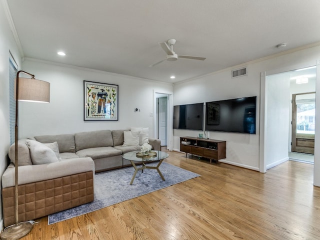 living room featuring plenty of natural light, ceiling fan, light hardwood / wood-style floors, and crown molding