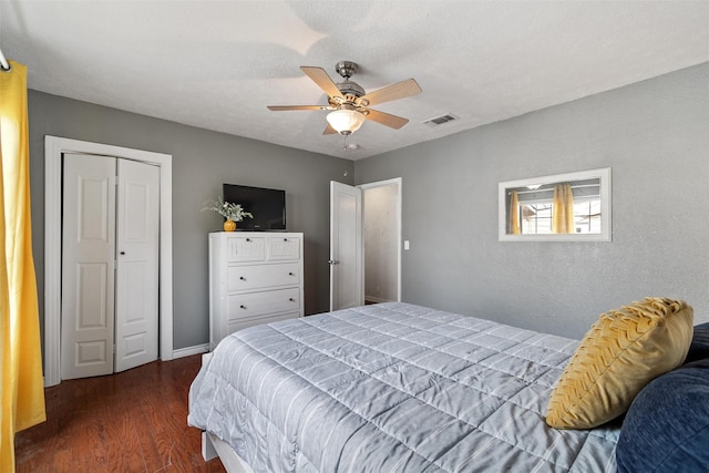 bedroom featuring ceiling fan, dark wood-type flooring, a closet, and a textured ceiling