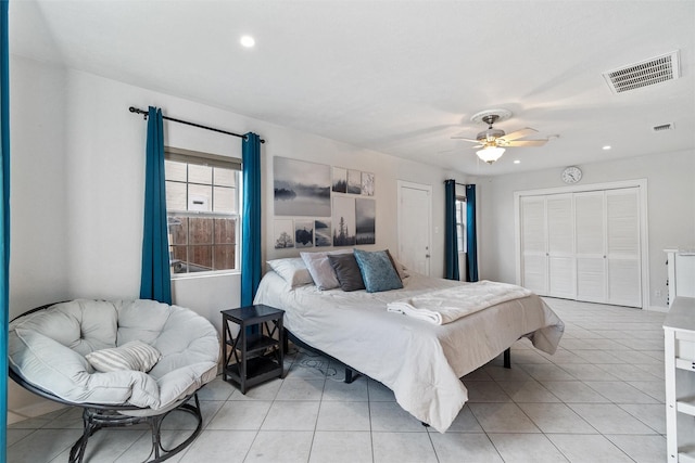 tiled bedroom with ceiling fan and a closet