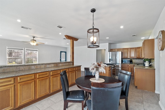 dining room featuring ceiling fan with notable chandelier and light tile patterned floors