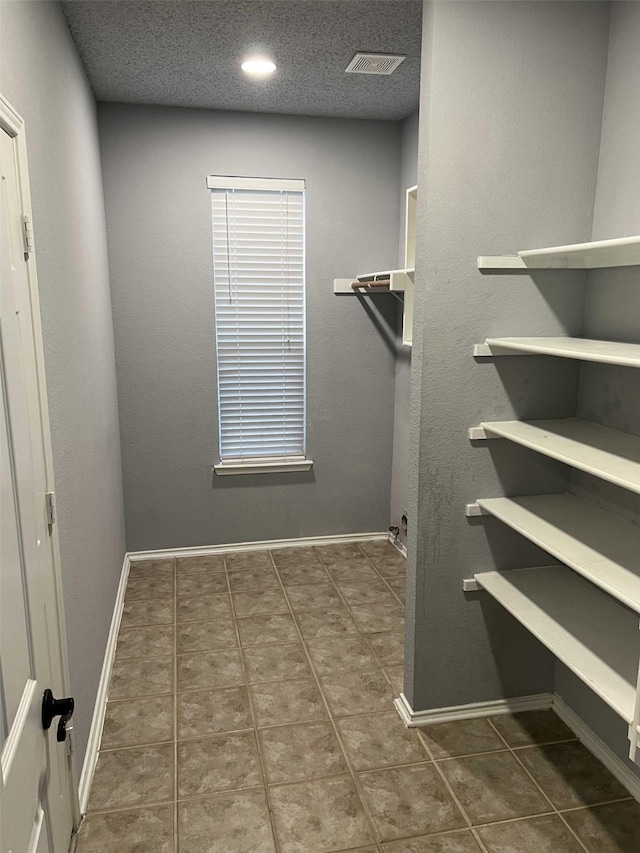 spacious closet with dark tile patterned floors