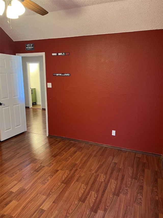 spare room with a textured ceiling, ceiling fan, and wood-type flooring