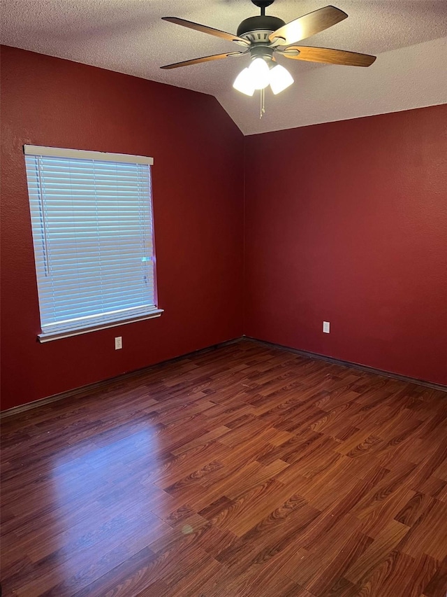 empty room featuring dark hardwood / wood-style flooring, a textured ceiling, and ceiling fan