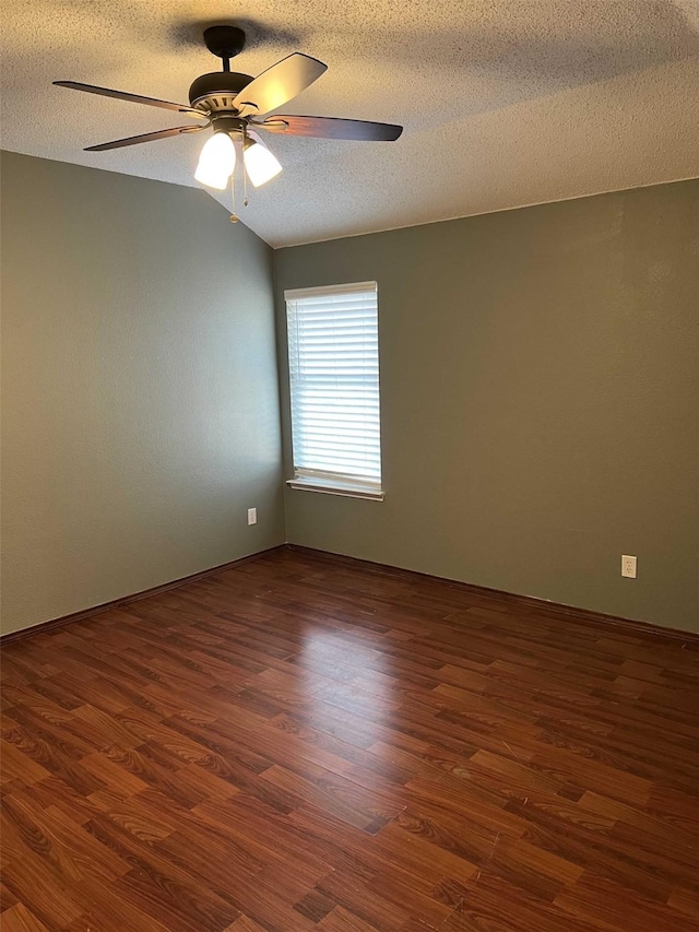 spare room featuring vaulted ceiling, a textured ceiling, ceiling fan, and dark hardwood / wood-style floors