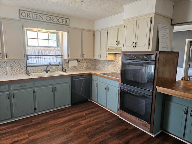 kitchen with sink, a textured ceiling, decorative backsplash, dark hardwood / wood-style flooring, and black appliances