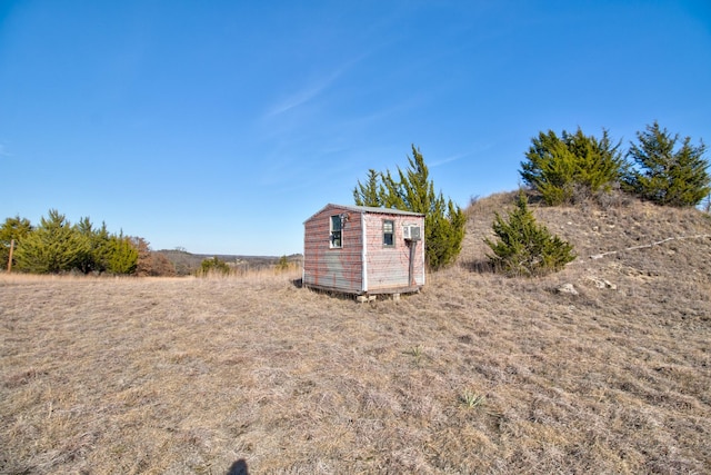 view of yard with a rural view and a storage shed