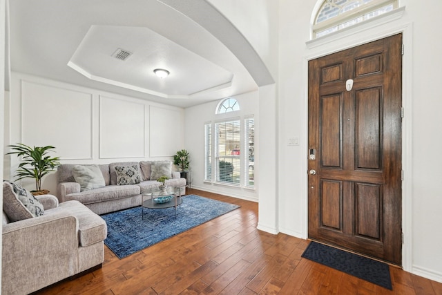 foyer featuring a raised ceiling and dark wood-type flooring