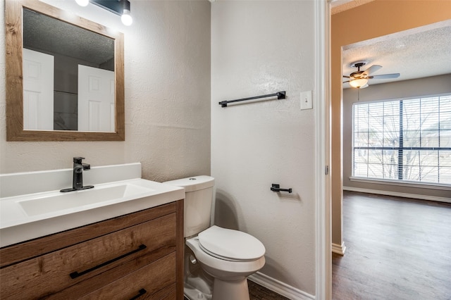 bathroom with a textured ceiling, ceiling fan, vanity, and toilet