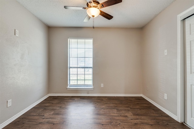 spare room with a textured ceiling, ceiling fan, plenty of natural light, and dark wood-type flooring