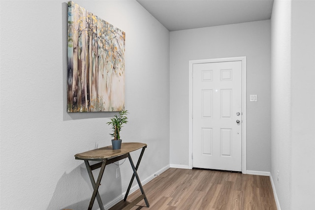 entryway with wood finished floors and baseboards