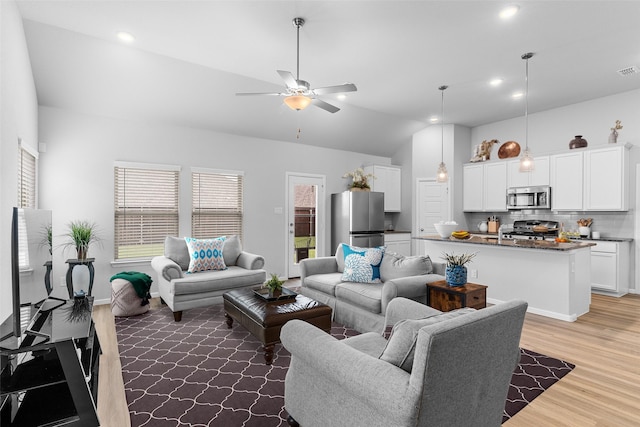 living room with lofted ceiling, recessed lighting, wood finished floors, visible vents, and a ceiling fan