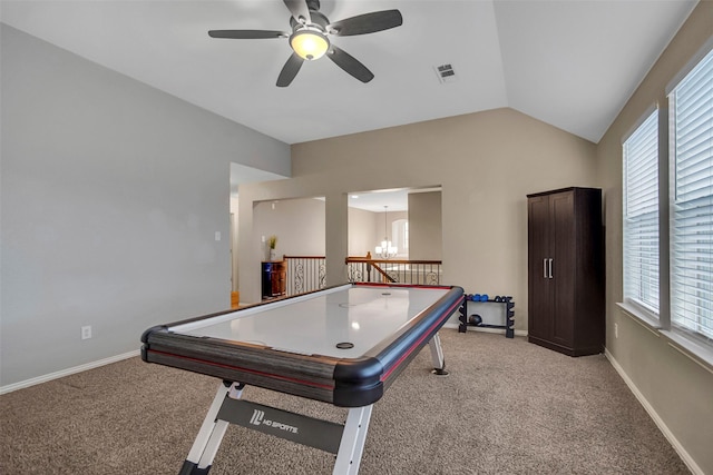 recreation room with ceiling fan with notable chandelier, light colored carpet, and vaulted ceiling