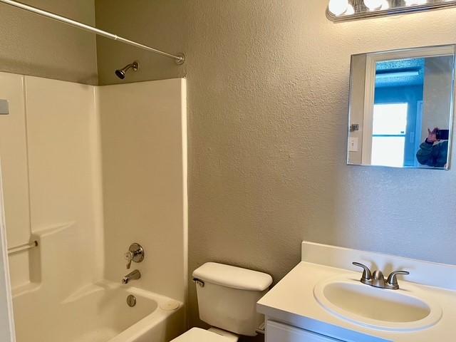 full bathroom featuring shower / tub combination, vanity, and toilet