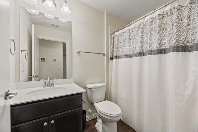 bathroom with toilet, wood-type flooring, and vanity