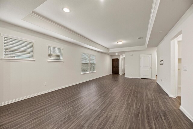 unfurnished living room featuring dark wood-type flooring and a raised ceiling