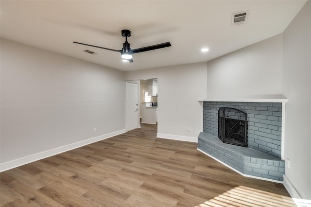 unfurnished living room featuring ceiling fan, a fireplace, and hardwood / wood-style flooring