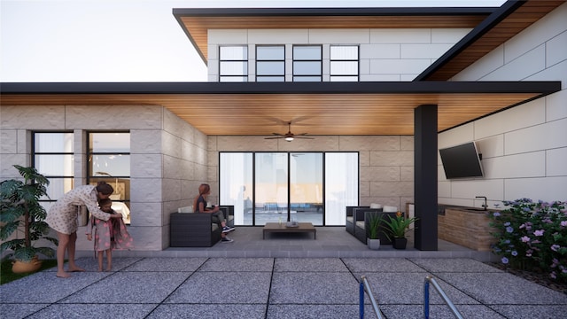 property entrance featuring a patio area, concrete block siding, and a ceiling fan