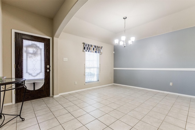 tiled entrance foyer featuring an inviting chandelier