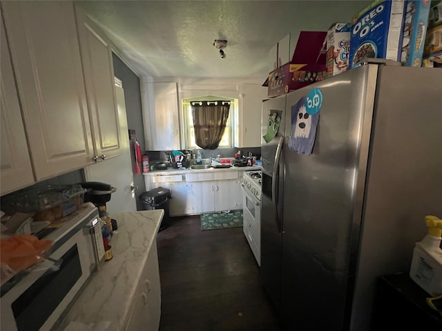 kitchen featuring white cabinets, a textured ceiling, white range with gas stovetop, and stainless steel refrigerator with ice dispenser