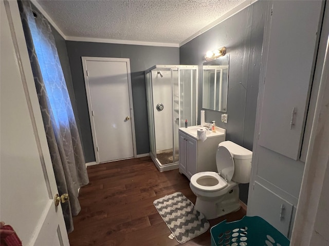 bathroom with a textured ceiling, walk in shower, vanity, and hardwood / wood-style flooring