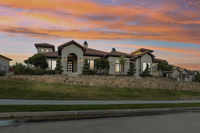 mediterranean / spanish house with french doors and a yard