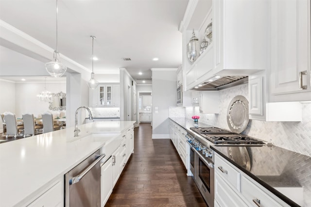 kitchen featuring pendant lighting, tasteful backsplash, white cabinets, appliances with stainless steel finishes, and sink